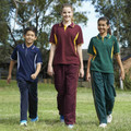 Three children walking outdoors wearing matching microfibre track pants with contrast piping in navy, maroon, and bottle green