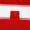 Close-up of red and white micro mesh raglan polo showing contrast panel seam and red button placket detail
