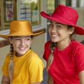 Two girls wearing broad brim slouch hats in gold and red with eyelet vents, shown in an outdoor school setting