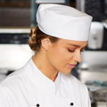 White chef cap with adjustable velcro closure and matching white chef jacket with black buttons