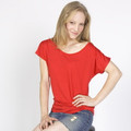 Woman wearing a red batwing sleeve relaxed-fit tee with scoop neckline and draped silhouette