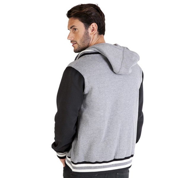 Man wearing grey marl and black varsity jacket with hood, striped ribbed hem, rear view