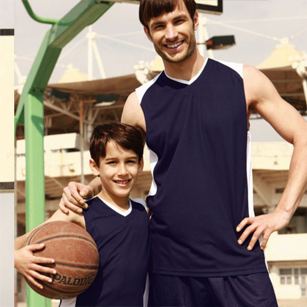 Adult and child wearing navy and white contrast basketball singlets on an outdoor court