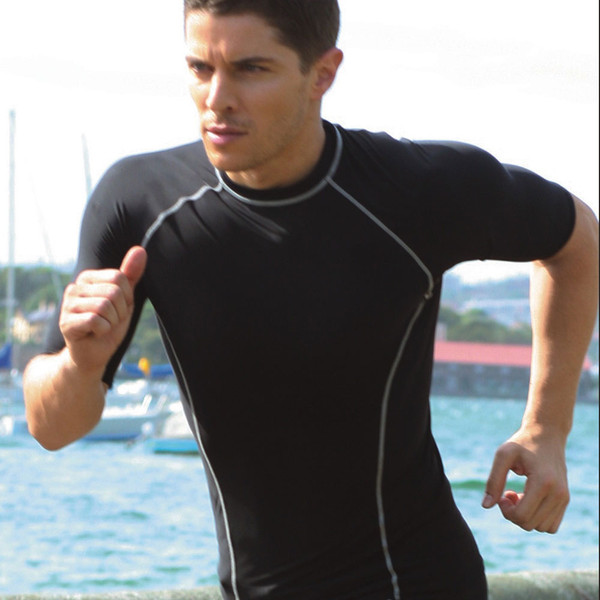 Man running outdoors in black compression short sleeve tee with grey contrast seam detailing