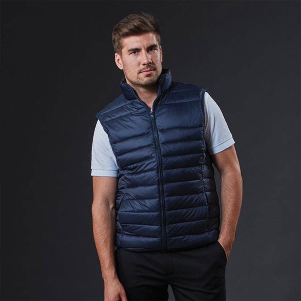 Navy quilted puffer vest with grey polo shirt showing horizontal channel stitching and full zip closure