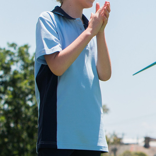 Child wearing sky blue and navy contrast panel short sleeve polo with tipped collar, outdoors