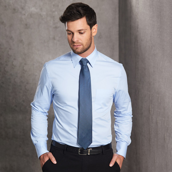 Light blue long sleeve fine twill dress shirt with pointed collar and chest pocket paired with navy tie