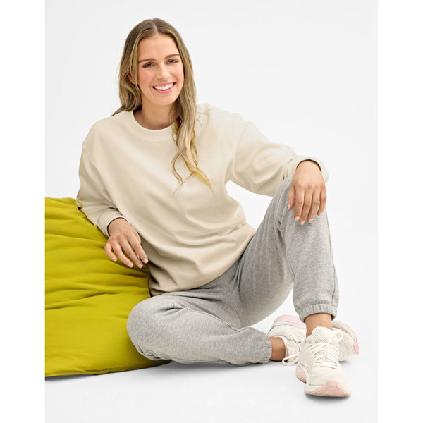Oversized cream sweater with ribbed cuffs paired with grey marle joggers, showing relaxed fit and clean neckline
