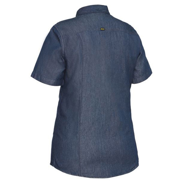 Back view of women's short sleeve denim work shirt in medium blue chambray with small logo tab at upper back