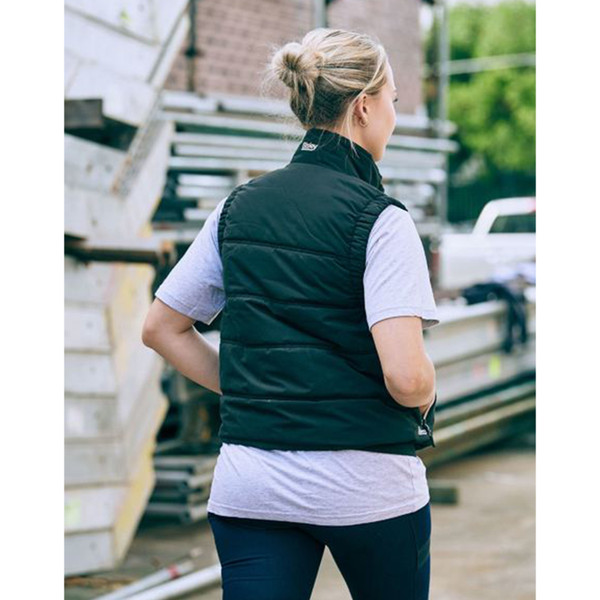 Woman wearing black quilted puffer vest on worksite, rear view showing collar and side pockets