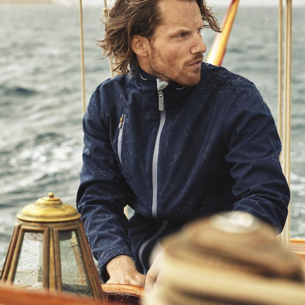 Navy softshell jacket with white contrast zipper and water-resistant finish worn on boat