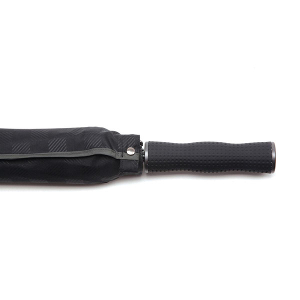 Close-up of folded black premium umbrella with textured rubber grip handle and subtle diagonal weave canopy fabric