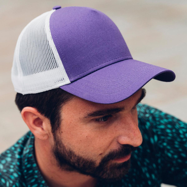 Man wearing purple and white mesh trucker cap with structured cotton twill front panel and curved brim
