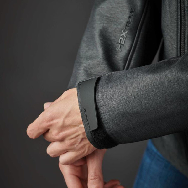 Close-up of charcoal heather jacket sleeve showing structured black Velcro cuff tab and zip placket detail