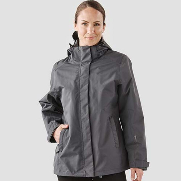 Woman wearing charcoal grey Stormtech waterproof system jacket with zip-off hood and zip pockets