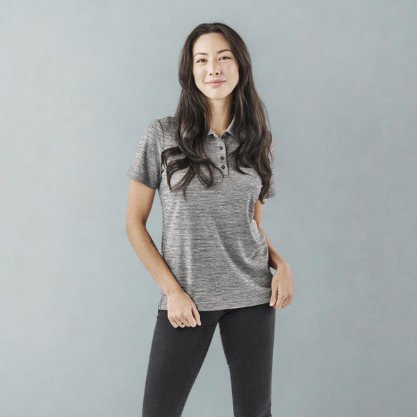 Woman wearing a heathered grey recycled sports polo with contrast collar and four-button placket