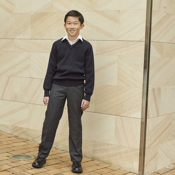 Boy wearing charcoal grey school trousers with ribbed waistband, styled with navy v-neck jumper and white shirt