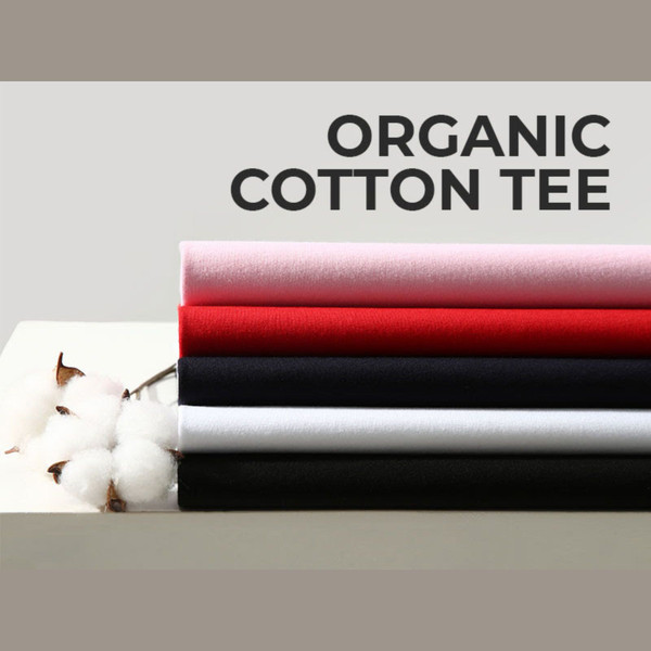 Stack of organic cotton t-shirts in pale pink, bright red, burgundy, white and black with cotton boll