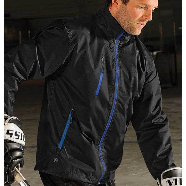 Man wearing black thermal shell jacket with royal blue zip details, chest zip pocket, angled lower pockets, and structured collar