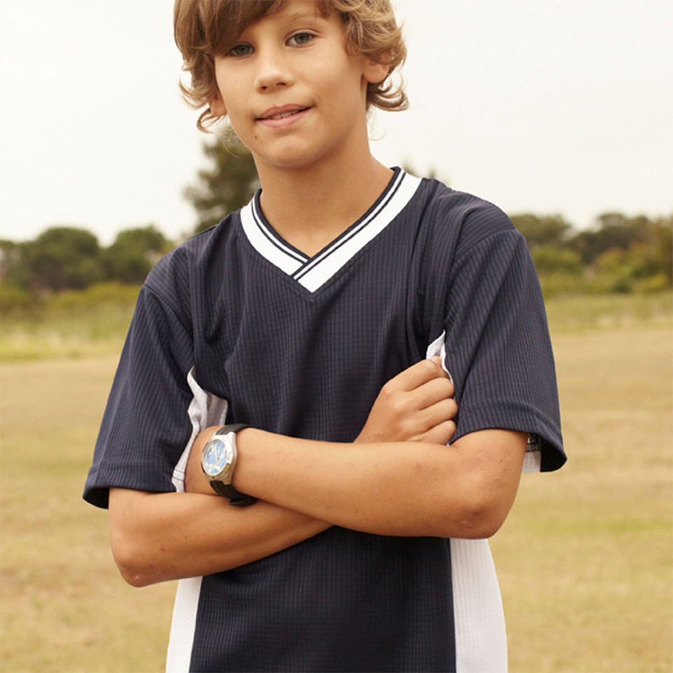 Boy wearing navy and white kids soccer jersey with V-neck stripe trim and contrast side panels