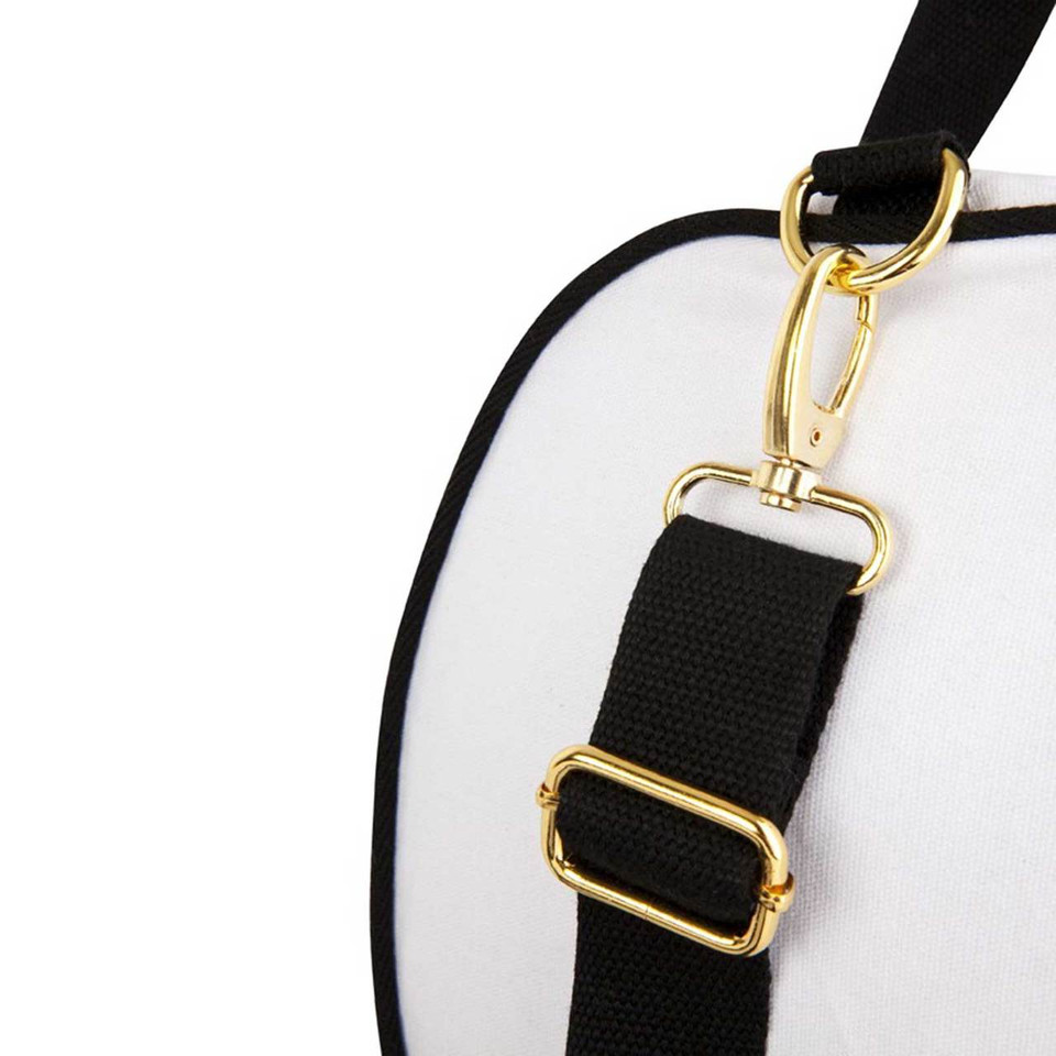 White canvas bag with black trim and adjustable black webbing strap with gold metal hardware