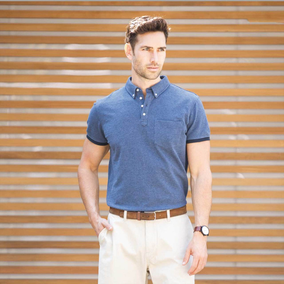 Man wearing denim-melange pique polo with button-down collar, navy tipping on cuffs and collar, and chest pocket