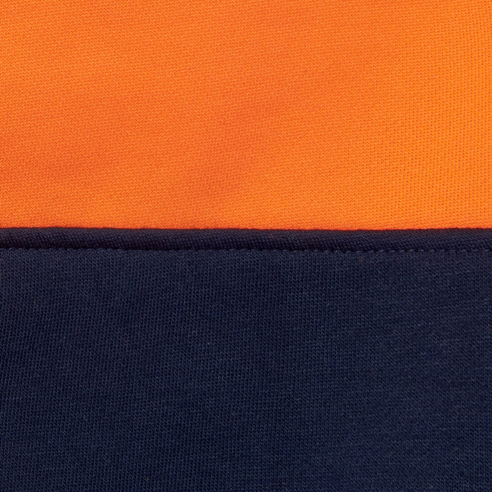 Close-up of hi vis orange and navy two-tone fleece fabric with contrast colour-block seam detail