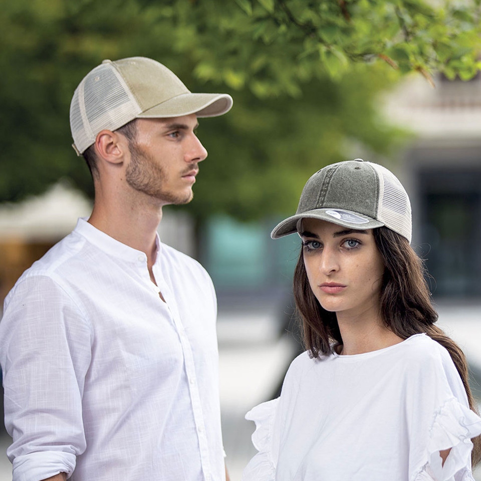 Two trucker caps with vintage wash fabric front panels and white mesh backs, showing sand and charcoal colourways