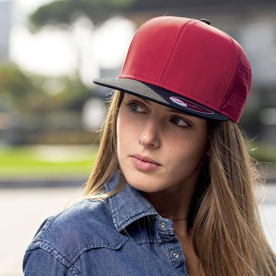 Model wearing red and charcoal structured snapback cap with flat brim and smooth front panels
