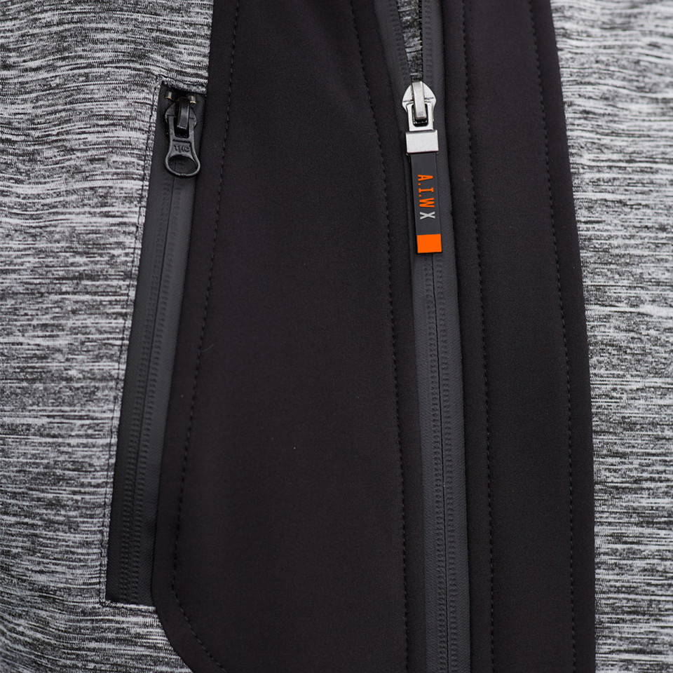 Black fleece jacket with contrast grey marle panels and double zipper detail with orange accent tab
