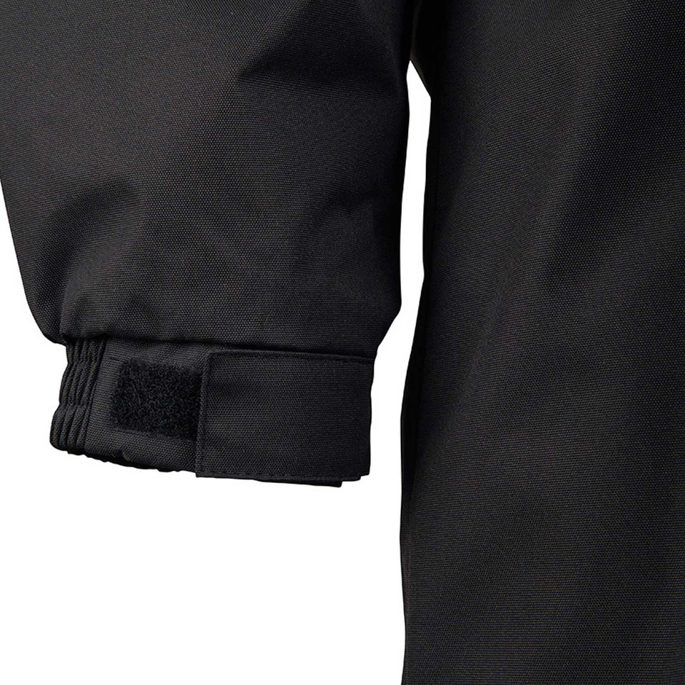 Close-up of black jacket cuff with elasticated rib and velcro tab fastening on smooth oxford shell fabric