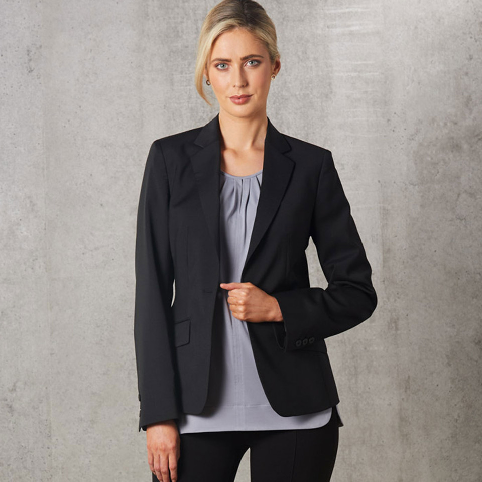 Woman wearing a charcoal tailored blazer with notch lapel, two-button front and flap pockets
