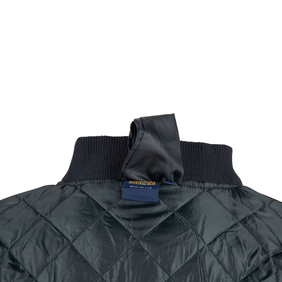 Navy quilted jacket with ribbed collar showing diamond stitch pattern and soft shell construction