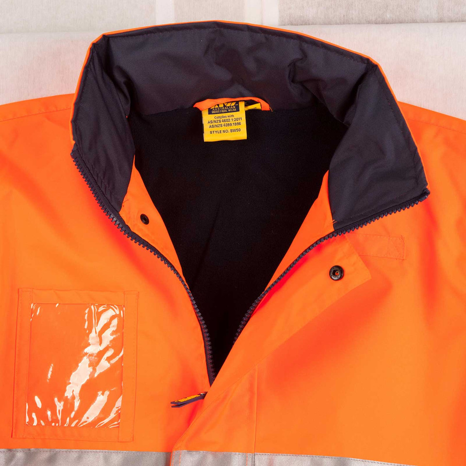 Orange and navy hi-vis safety jacket flat lay showing zip front, contrast collar lining, and clear ID pocket on chest