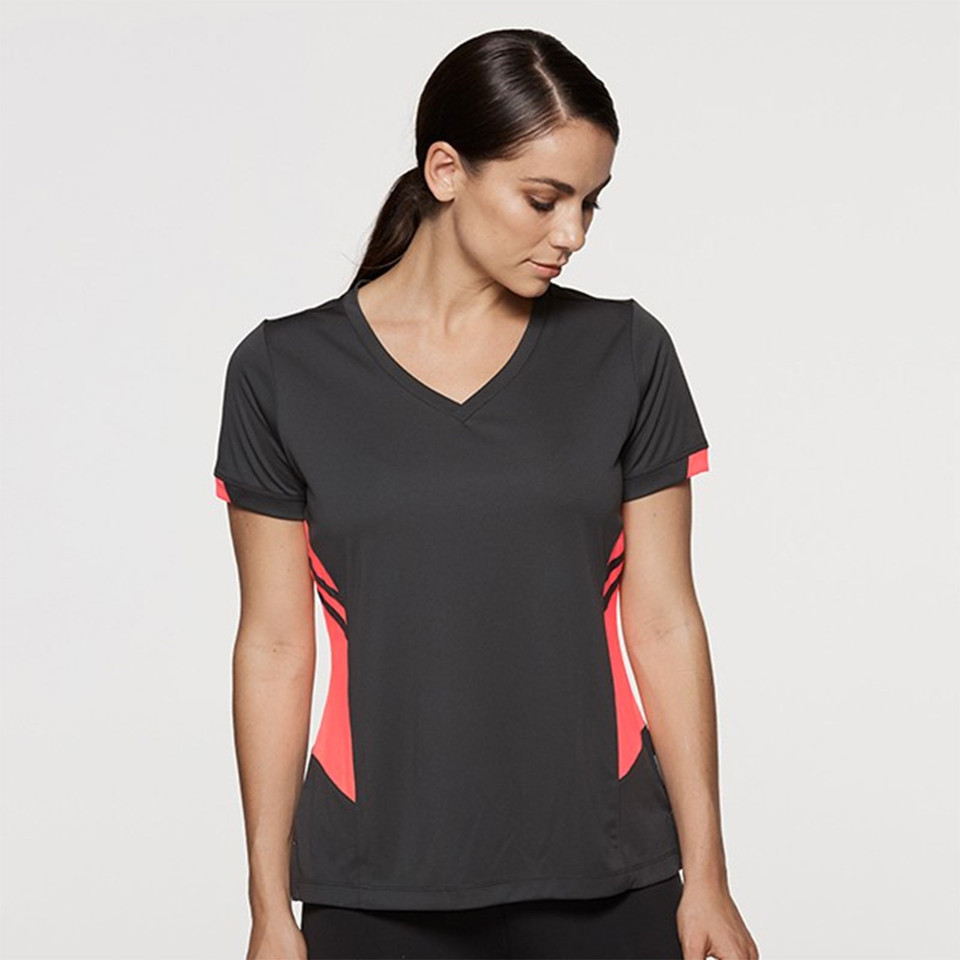 Woman wearing charcoal v-neck sports tee with coral and white contrast side panels, short sleeves
