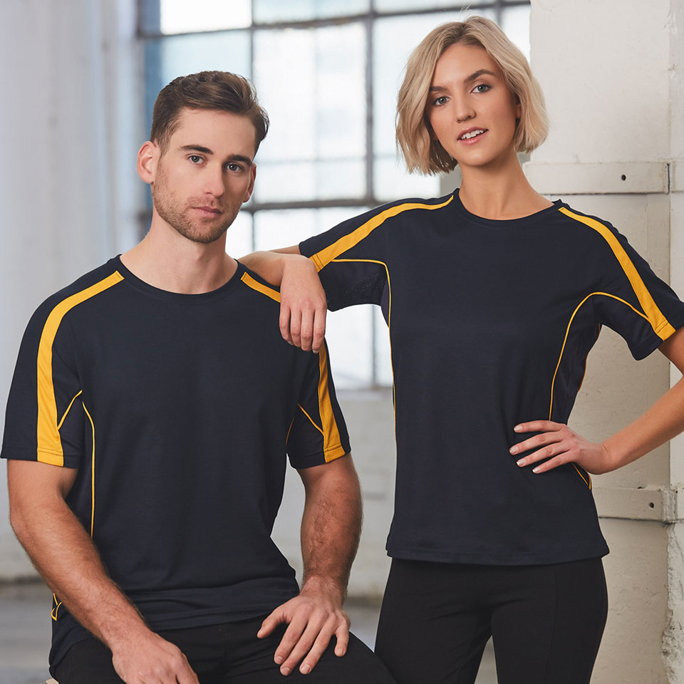 Male and female models wearing navy and gold contrast panel crew neck sport tees in an industrial setting