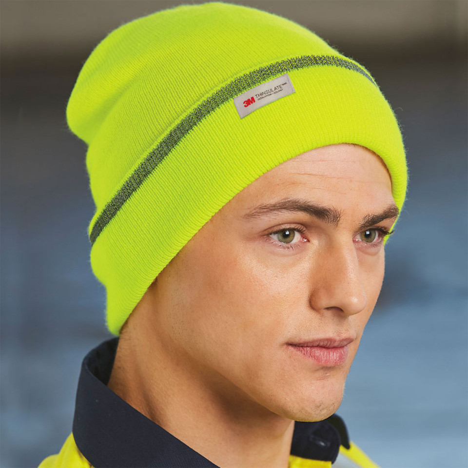 Man wearing hi-vis yellow knit beanie with grey 3M reflective tape stripe and woven label