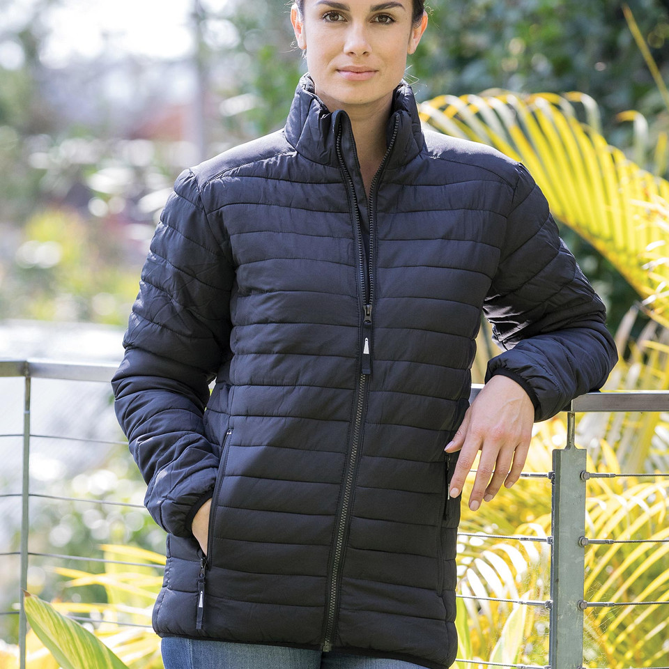 Woman wearing a midnight navy quilted puffer jacket with stand collar, full-length zip and side pockets, outdoors