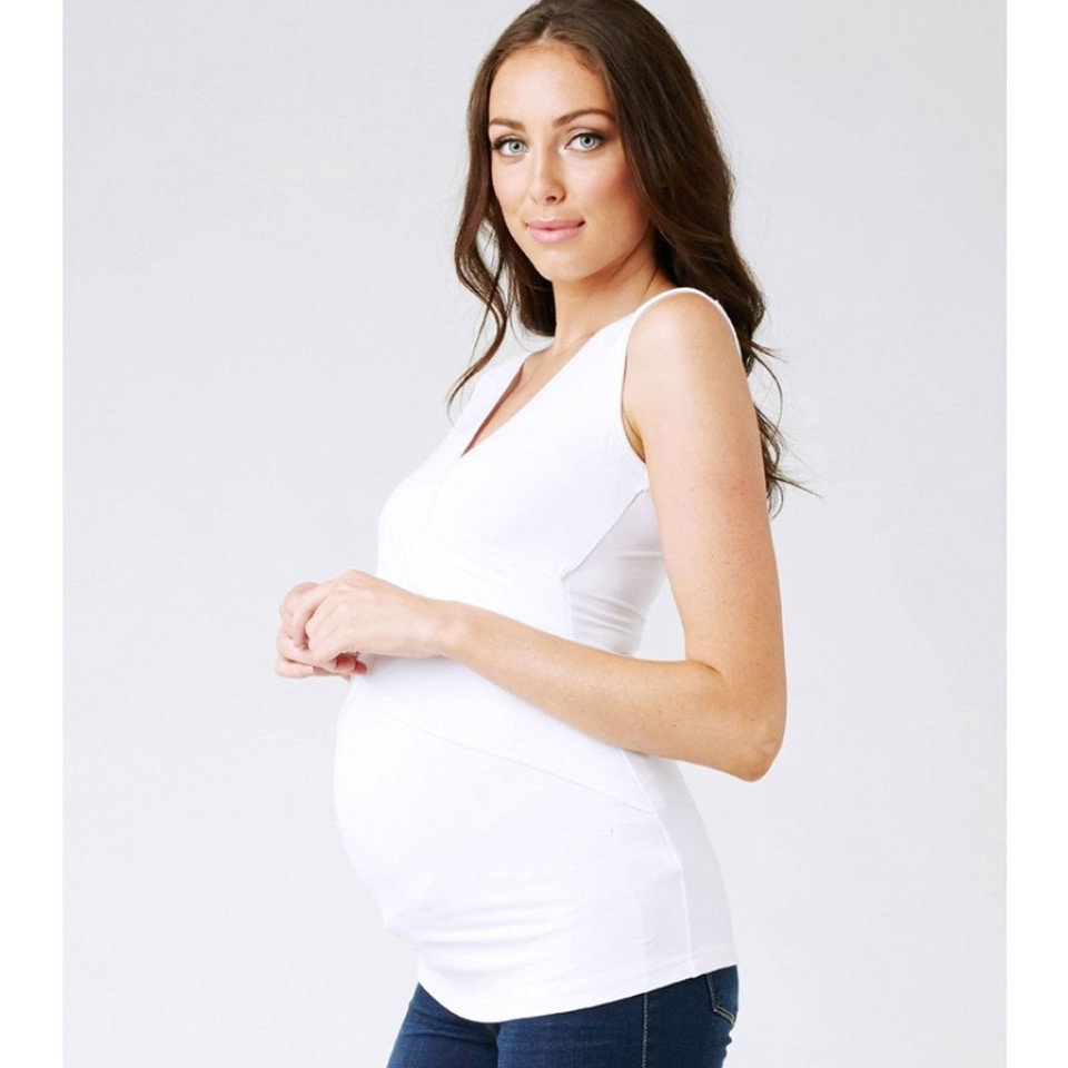 Pregnant model wearing white sleeveless V-neck maternity tank top with ruched side panels