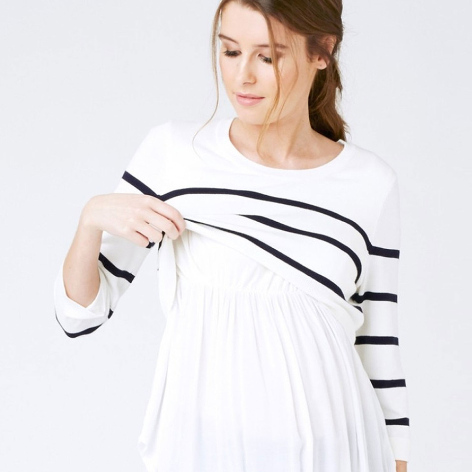 Model wearing white and navy stripe long-sleeve nursing knit with gathered babydoll hem, lifting overlay panel