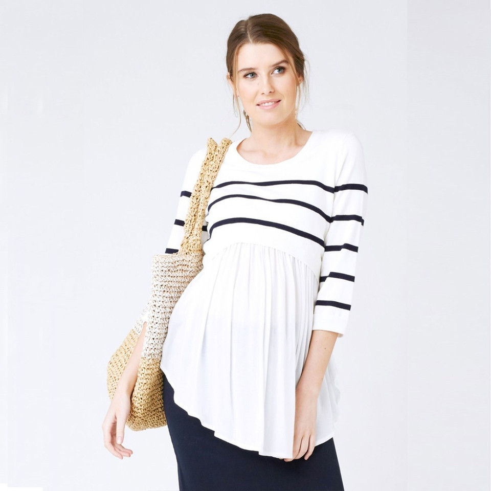 Model wearing white and navy stripe knit top with gathered babydoll hem and three-quarter sleeves
