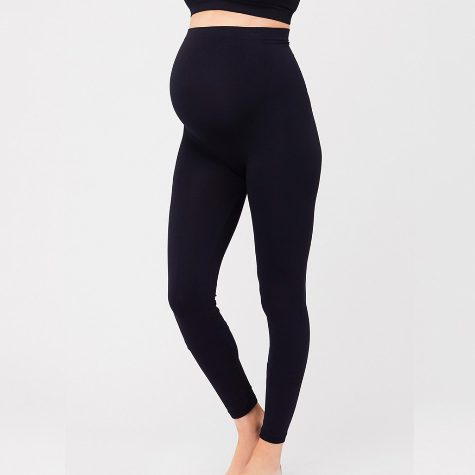 Black maternity leggings with wide seamless over-bump support panel, worn by model, side angle view