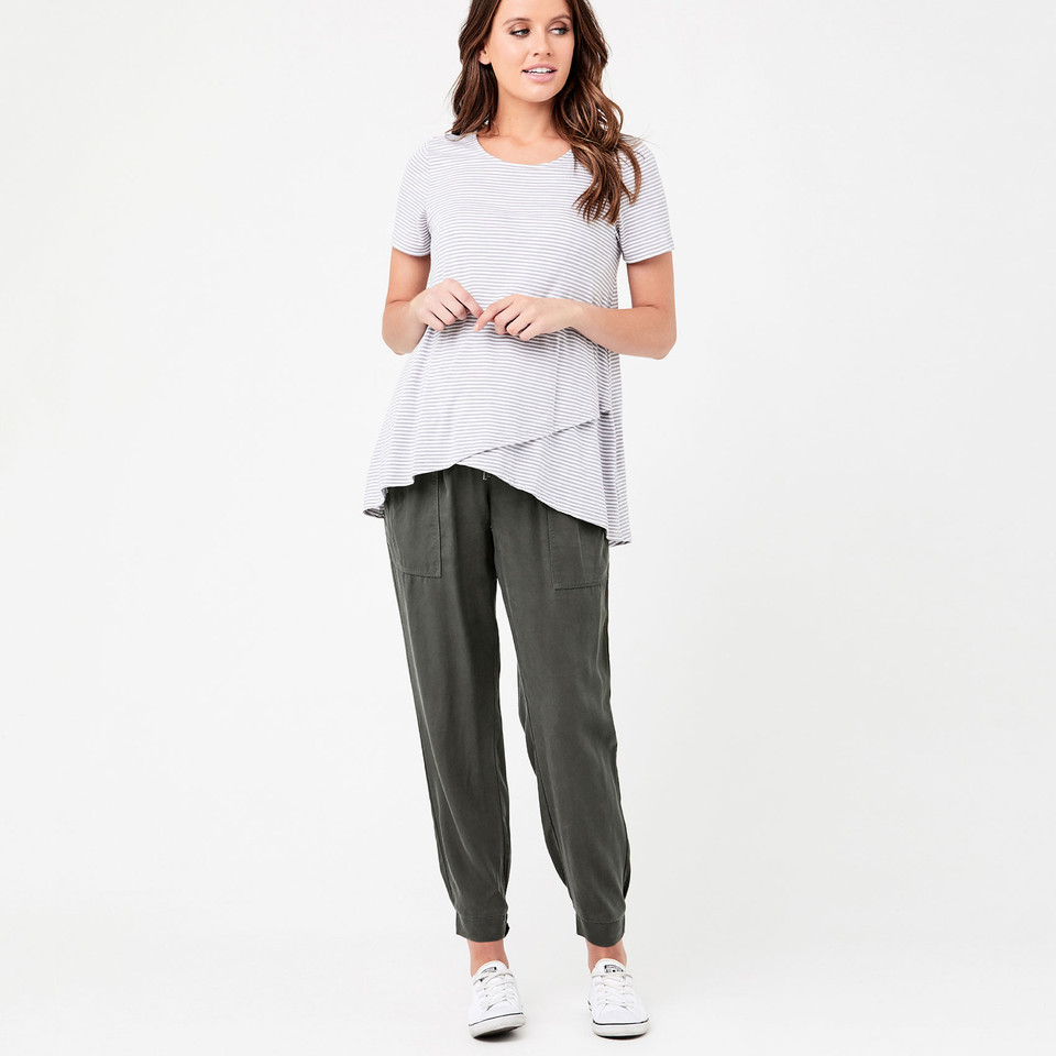 Model wearing olive tapered jogger pants with front patch pockets and cuffed ankles