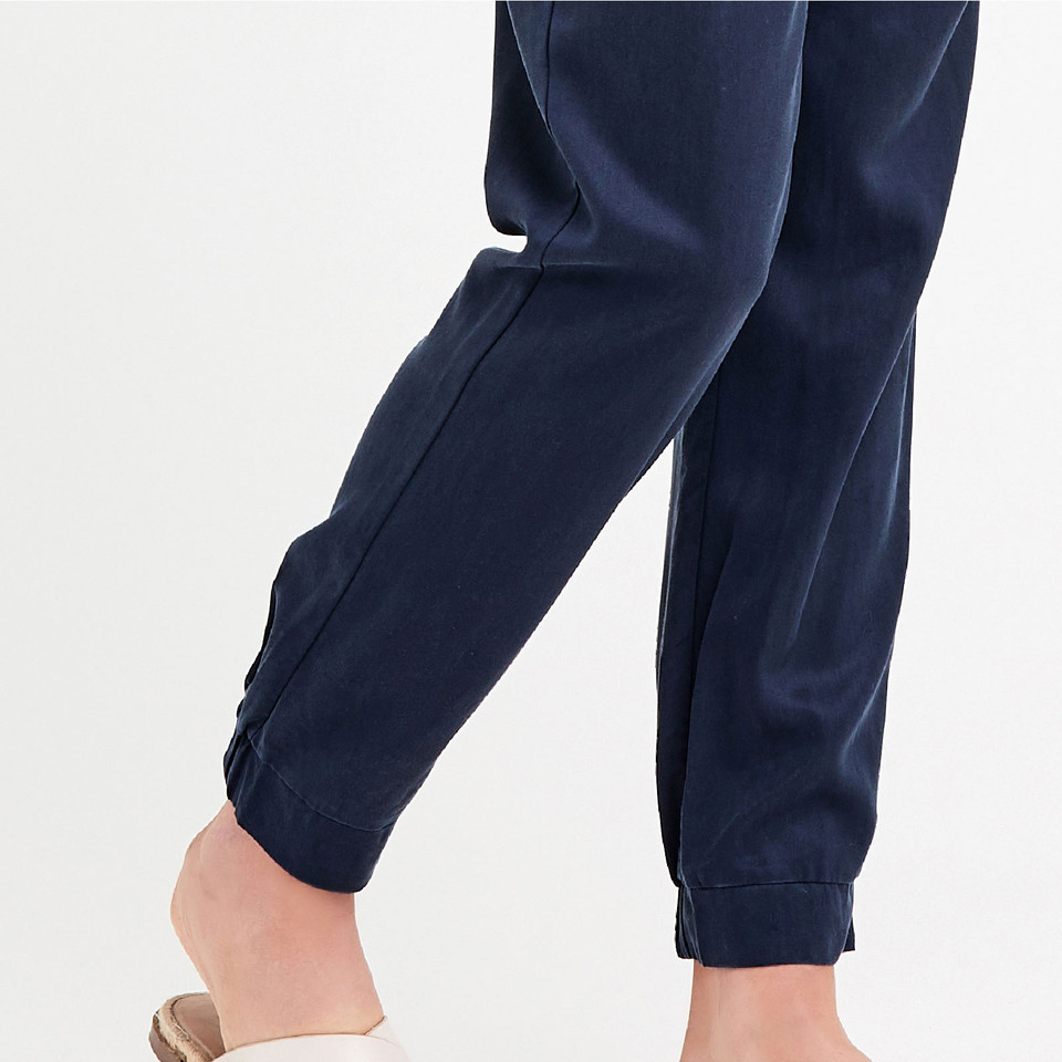 Navy Tencel jogger pant with ribbed cuff hem, worn by model with neutral sandals