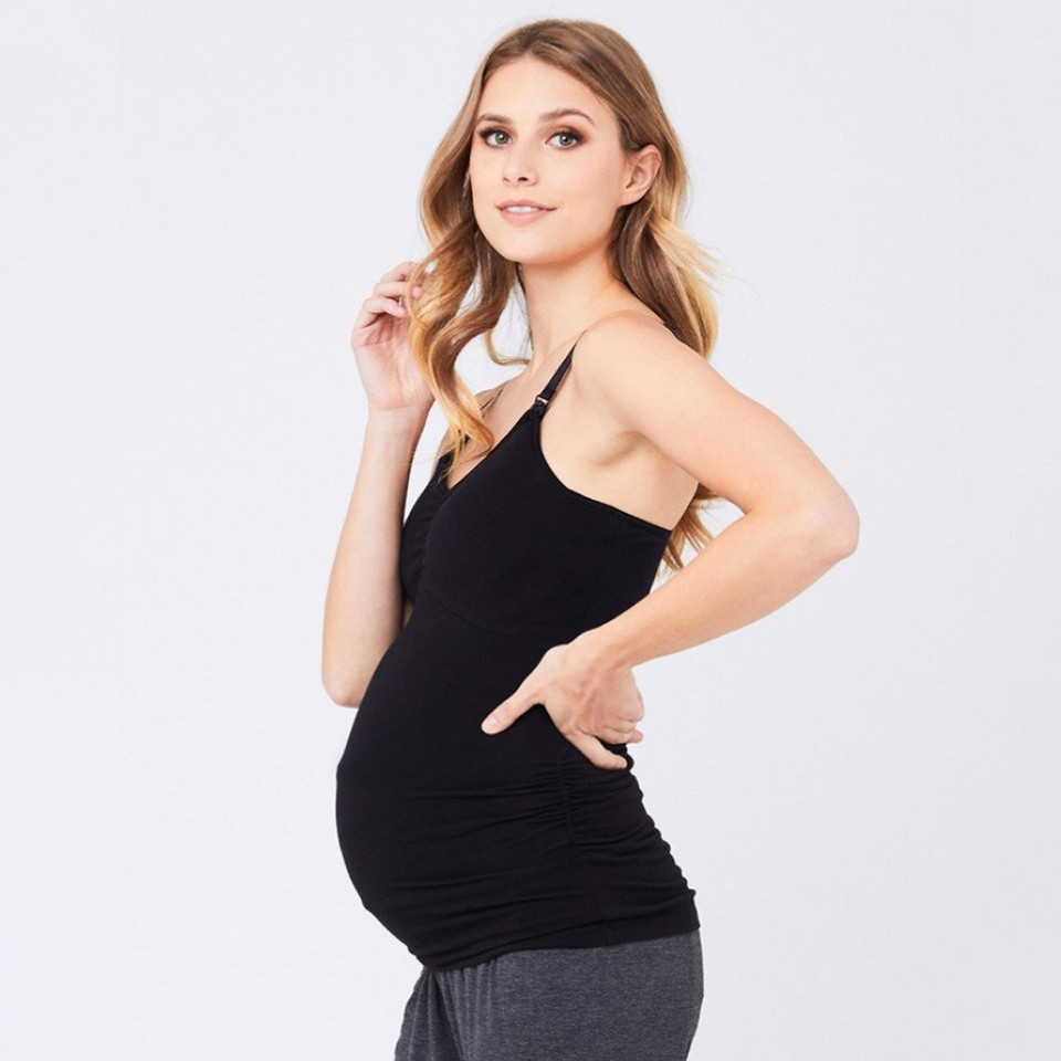 Pregnant model wearing black maternity cami tank with adjustable straps and ruched sides, side profile view