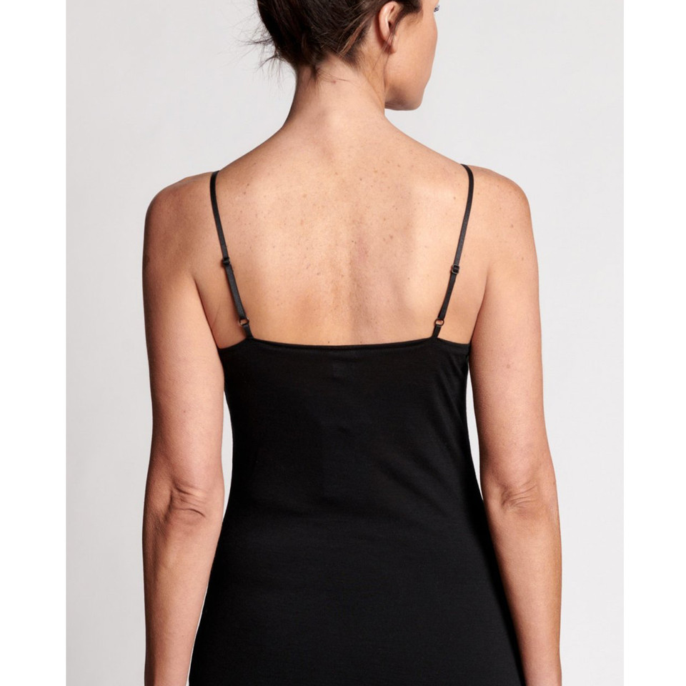 Back view of model wearing black wool lyocell camisole with adjustable thin straps and smooth fitted silhouette