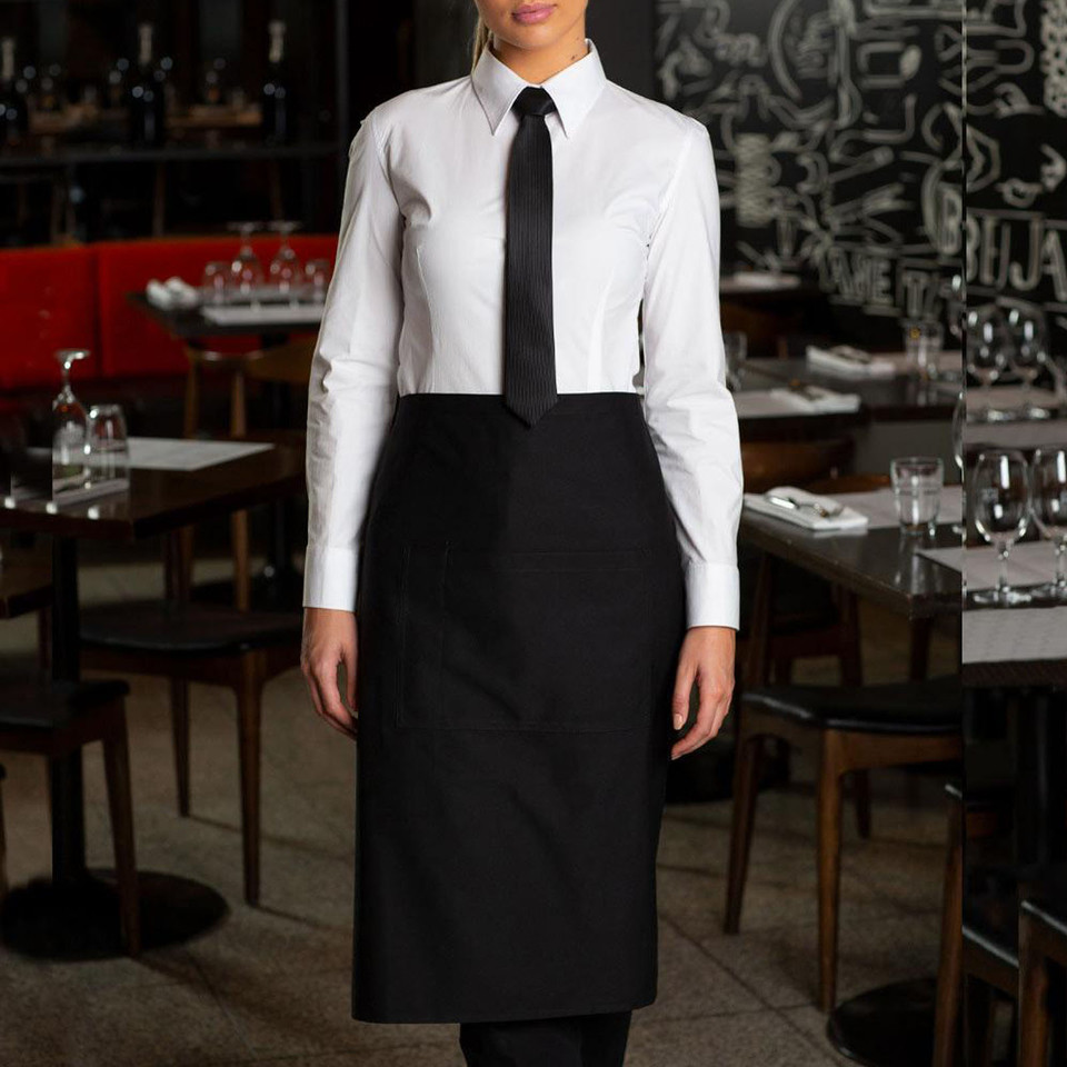 Black three-quarter length waist apron with flat front panel worn over white shirt and black tie in restaurant setting