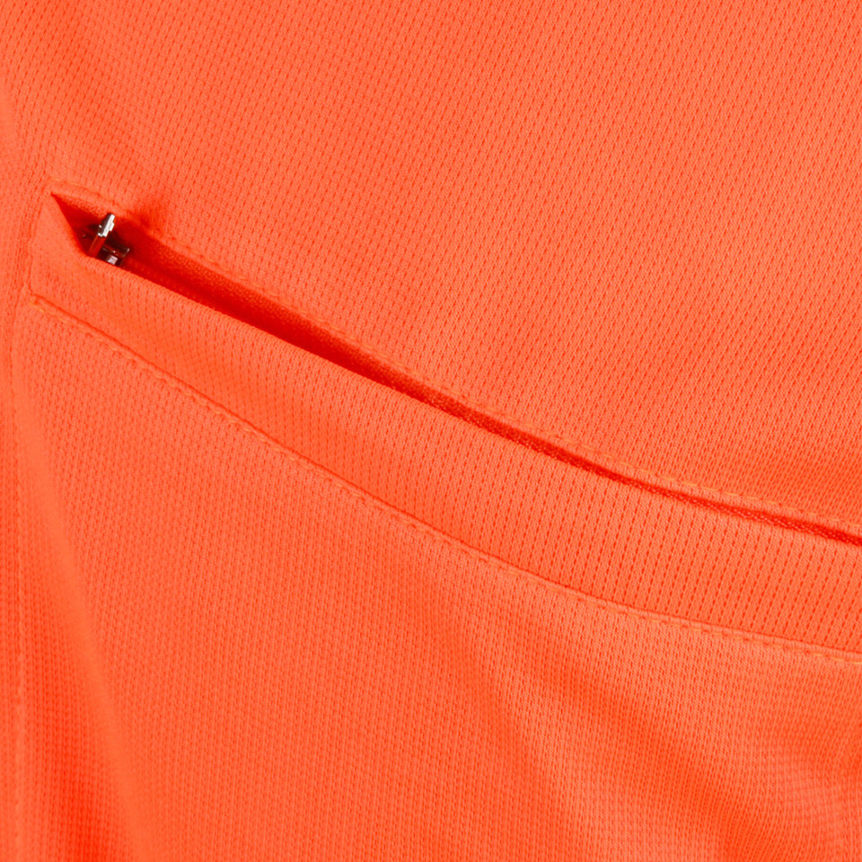 Bright orange polo shirt featuring zippered chest pocket with black zipper pull detail