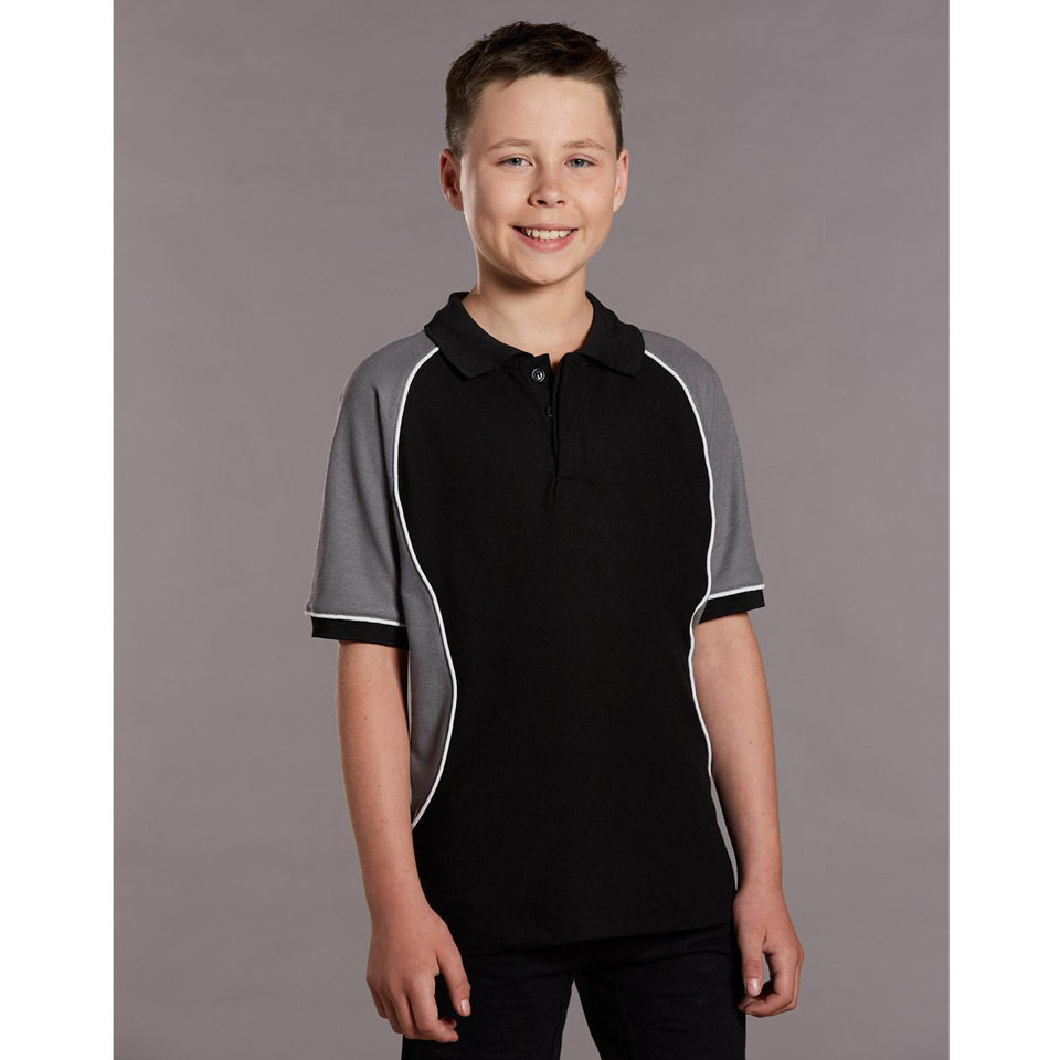 Boy wearing black pique polo with charcoal raglan panels and white contrast piping trim