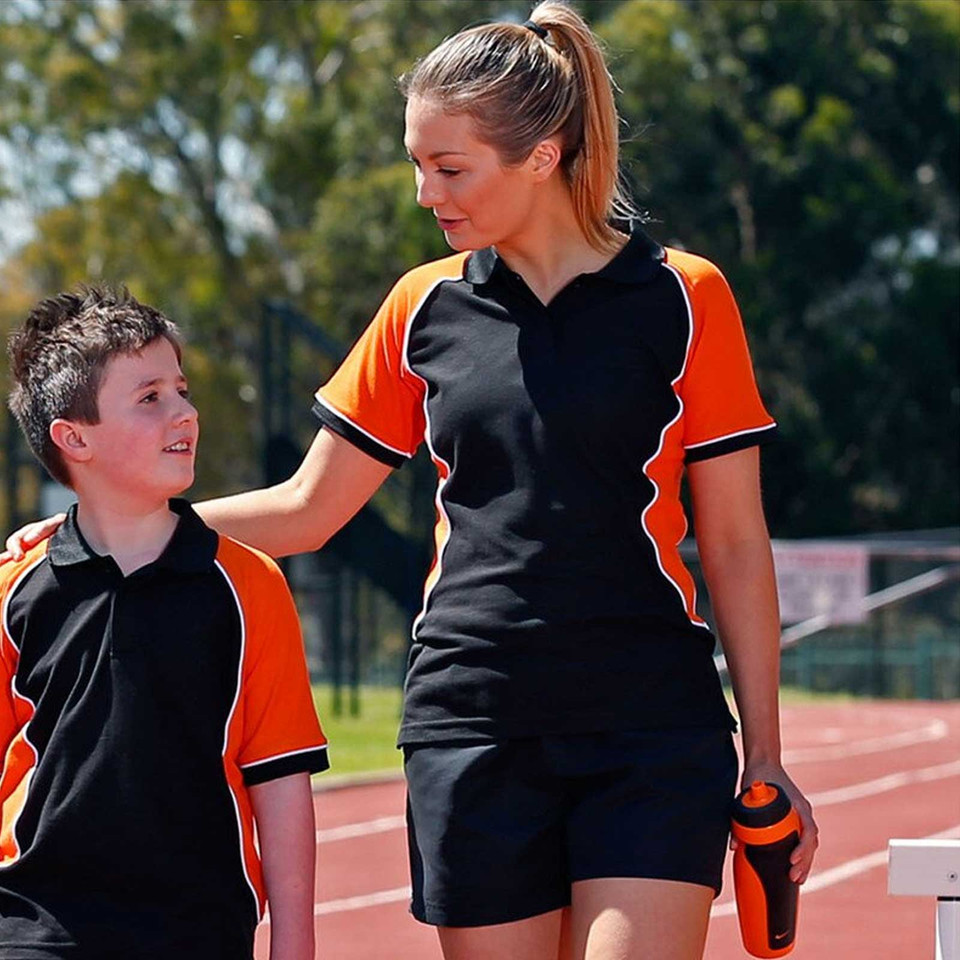 Woman and boy at athletics track in black and orange tri-colour pique polo shirts with curved contrast panels